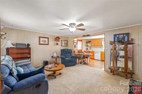 a living room with furniture a ceiling fan and a window