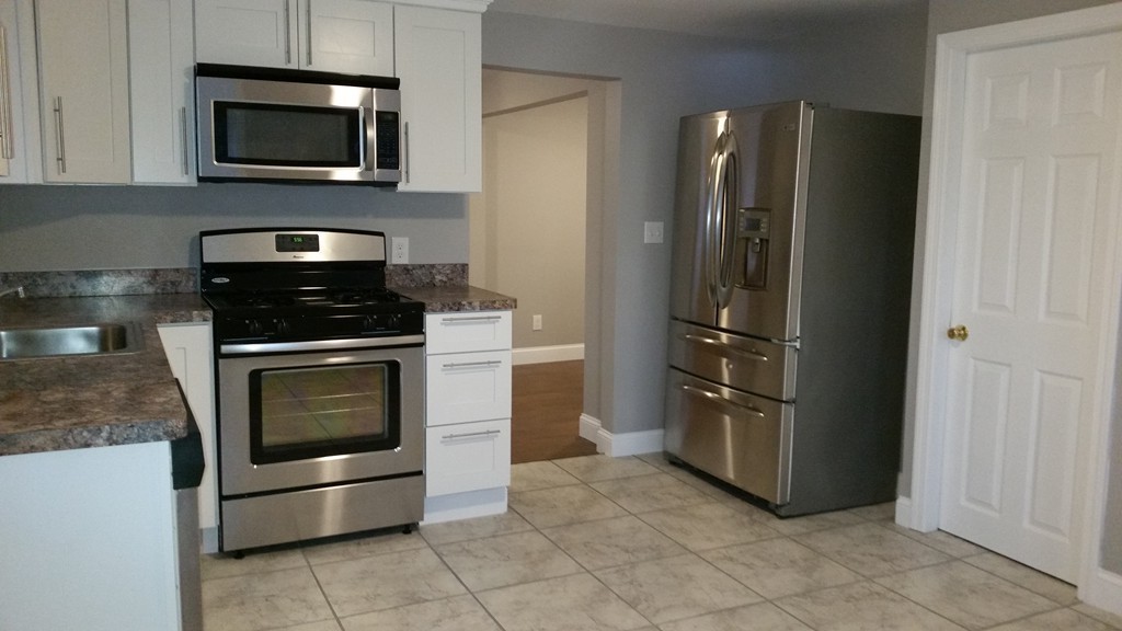 49 Drexel Street Springfield, MA 01104 - Photo 2 of 30 a kitchen with stainless steel appliances granite countertop a refrigerator and a stove top oven