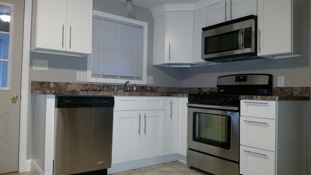 49 Drexel Street Springfield, MA 01104 - Photo 4 of 30 a kitchen with granite countertop white cabinets and black appliances