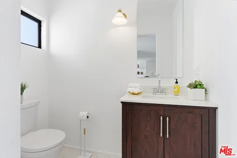 a bathroom with a granite countertop sink and a toilet