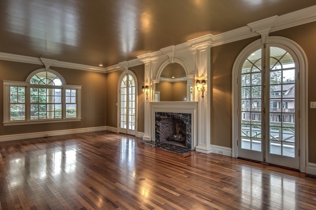 7 Percy Road Lexington, MA 02421 - Photo 11 of 29 an empty room with wooden floor fireplace and windows