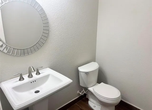 a white toilet sitting next to a white sink
