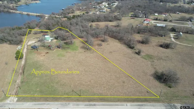 a view of a house with a wooden deck and a yard