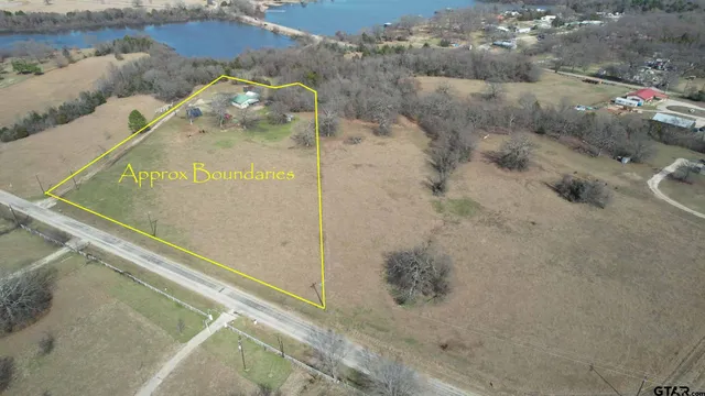 an aerial view of a house with a yard and lake view