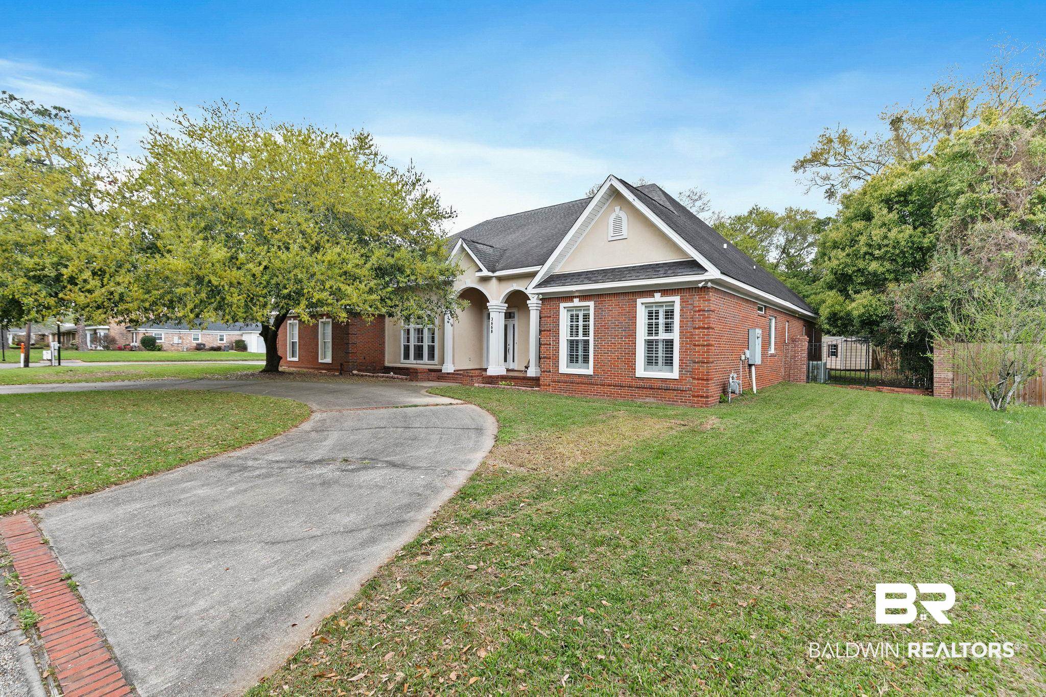 3668 Claridge Road North Mobile, AL 36608 - Photo 2 of 100 View of front of property featuring brick siding, roof with shingles, stucco siding, and driveway