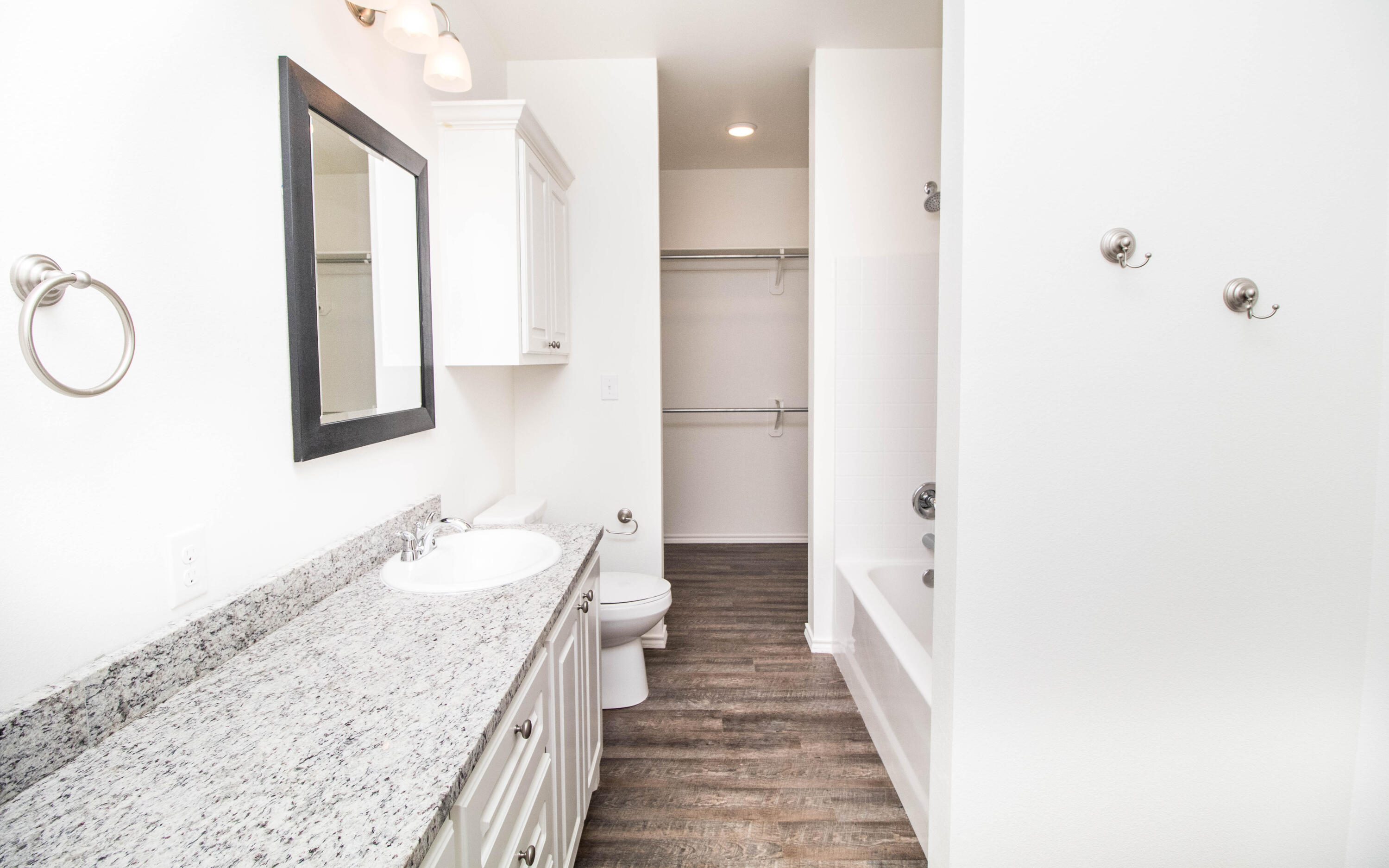 6914 21st Street Lubbock, TX 79407 - Photo 16 of 36 a bathroom with a granite countertop sink and a mirror
