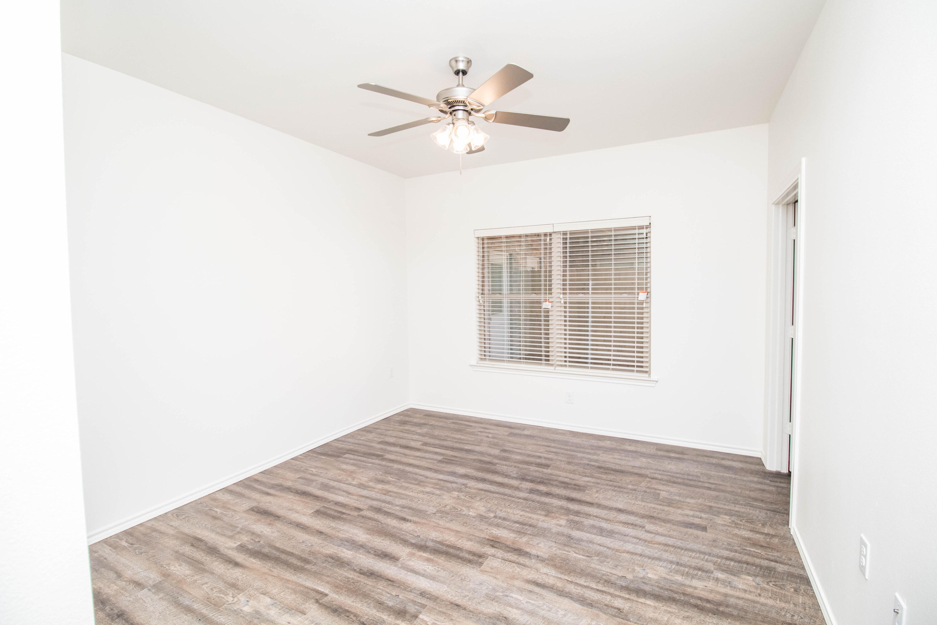 6914 21st Street Lubbock, TX 79407 - Photo 21 of 36 a view of a room with a ceiling fan and a window