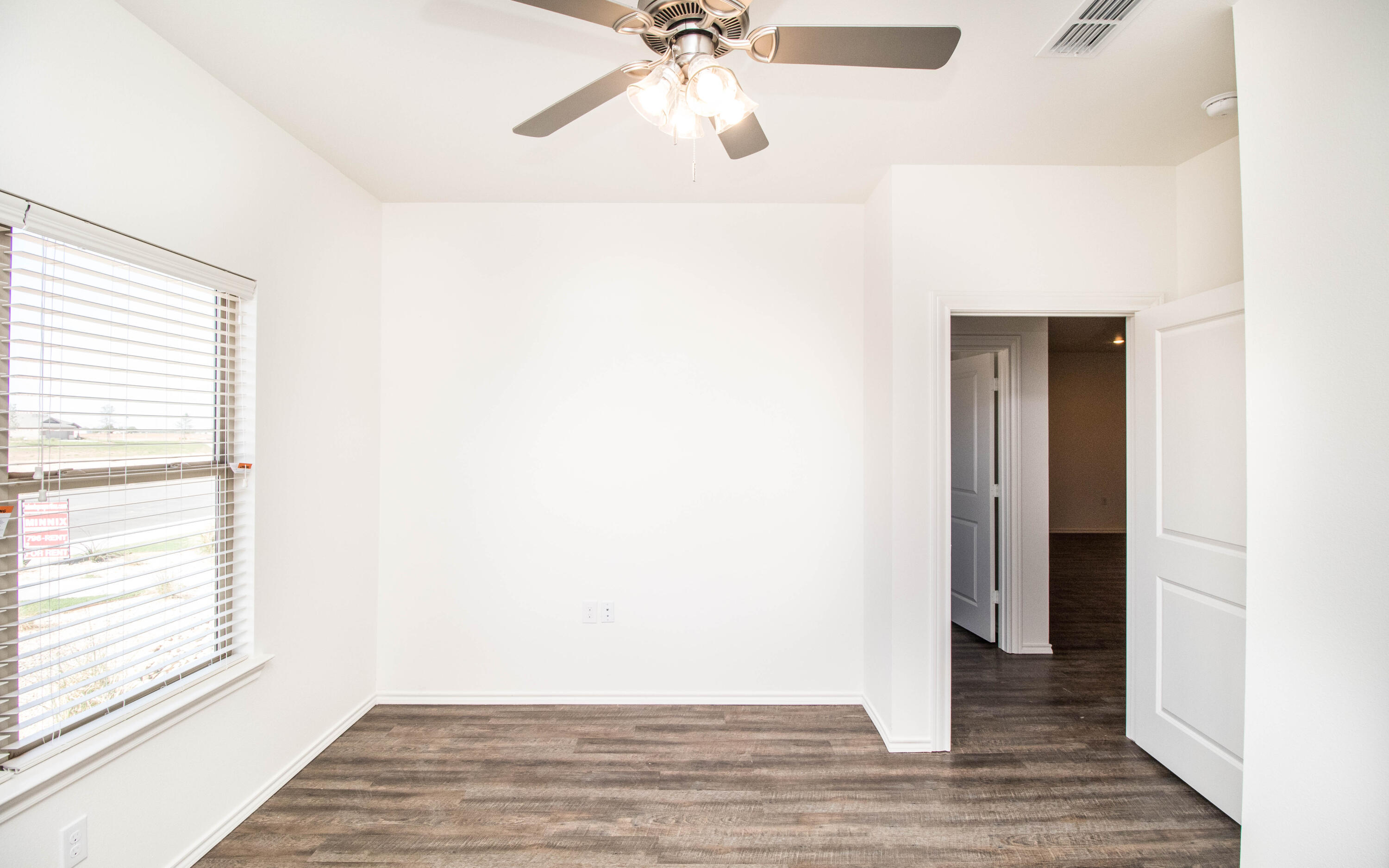 6914 21st Street Lubbock, TX 79407 - Photo 29 of 36 a view of a livingroom with wooden floor and a ceiling fan