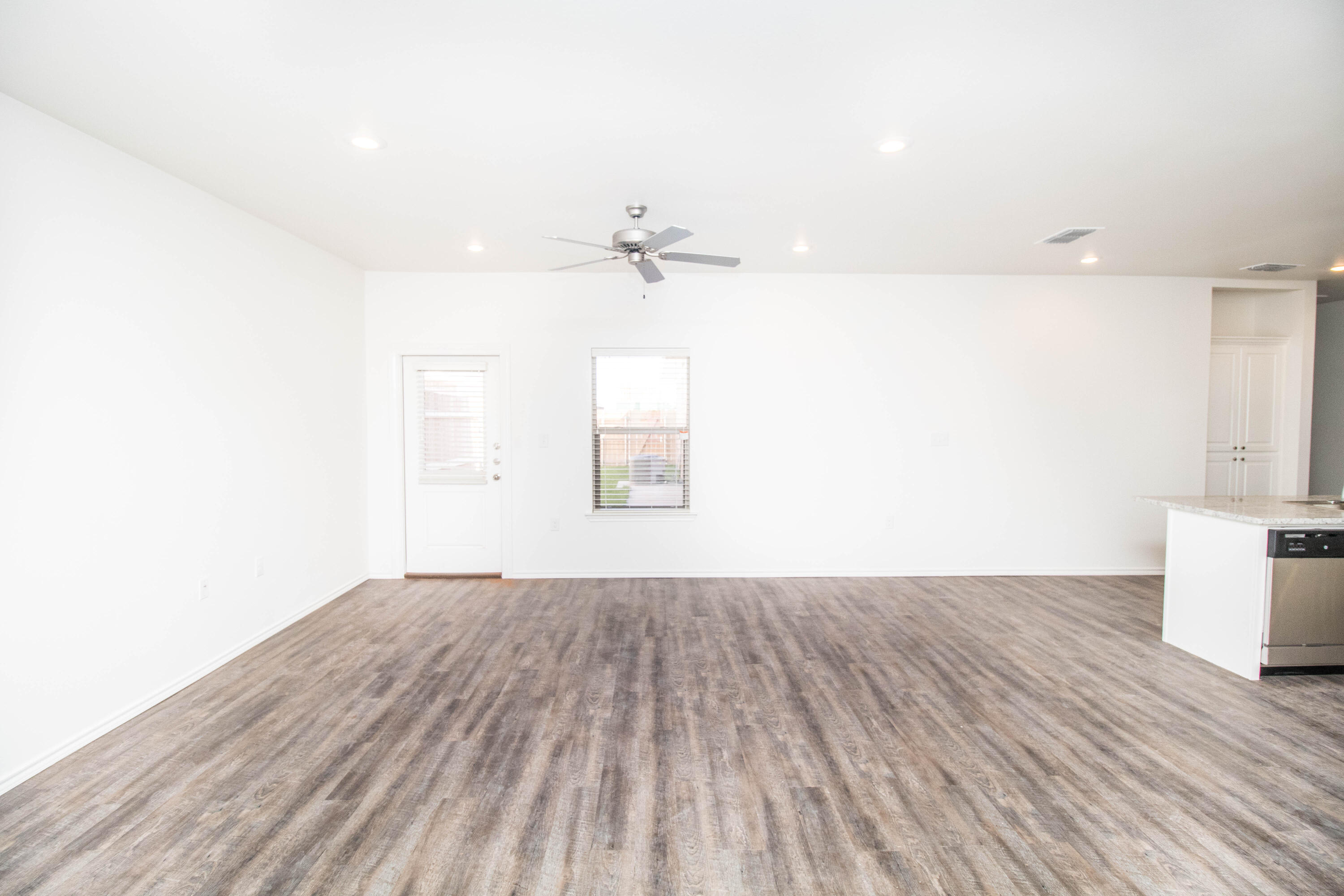 6914 21st Street Lubbock, TX 79407 - Photo 10 of 36 an empty room with wooden floor and windows