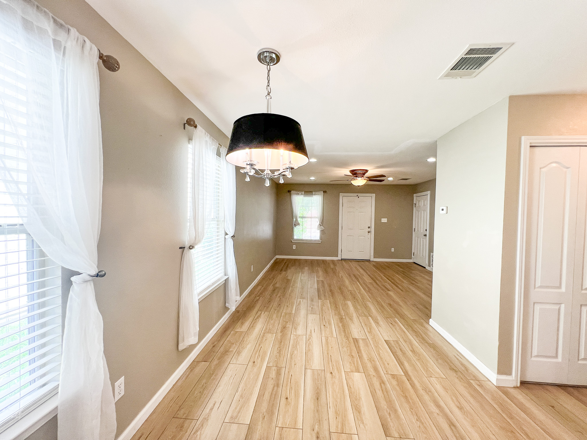 298 Jack Rabbit Lane Buda, TX 78610 - Photo 3 of 24 Bright, open-concept living space features wood-look flooring and a contemporary chandelier, ready for your personal touch.