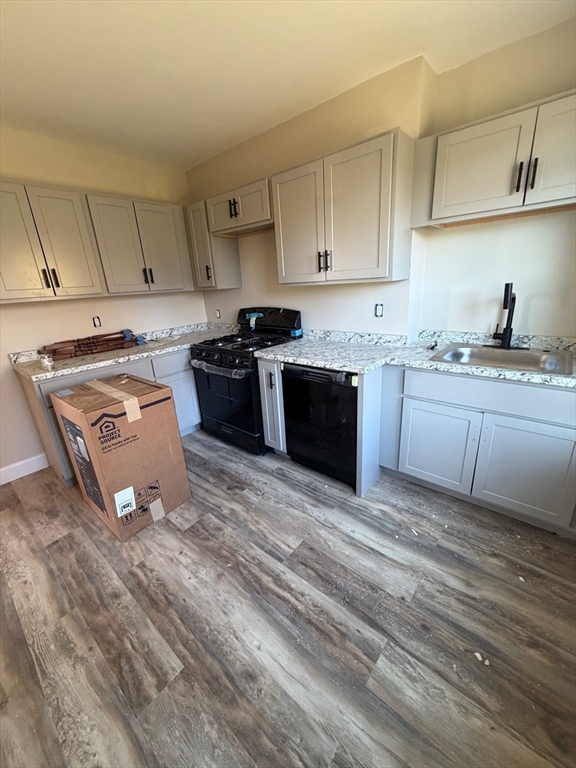 57 Colfax Street, Unit 57 Fall River, MA 02720 - Photo 2 of 7 a kitchen with stainless steel appliances granite countertop a stove a sink and a microwave