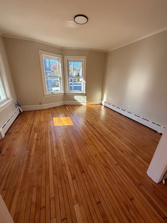 57 Colfax Street, Unit 57 Fall River, MA 02720 - Photo 3 of 7 an empty room with wooden floor and windows