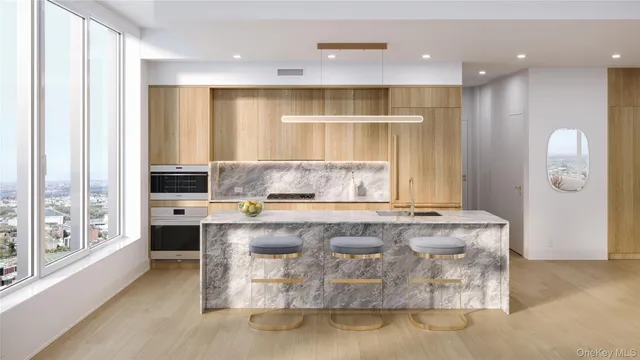 a living room with stainless steel appliances granite countertop a couch and a large window