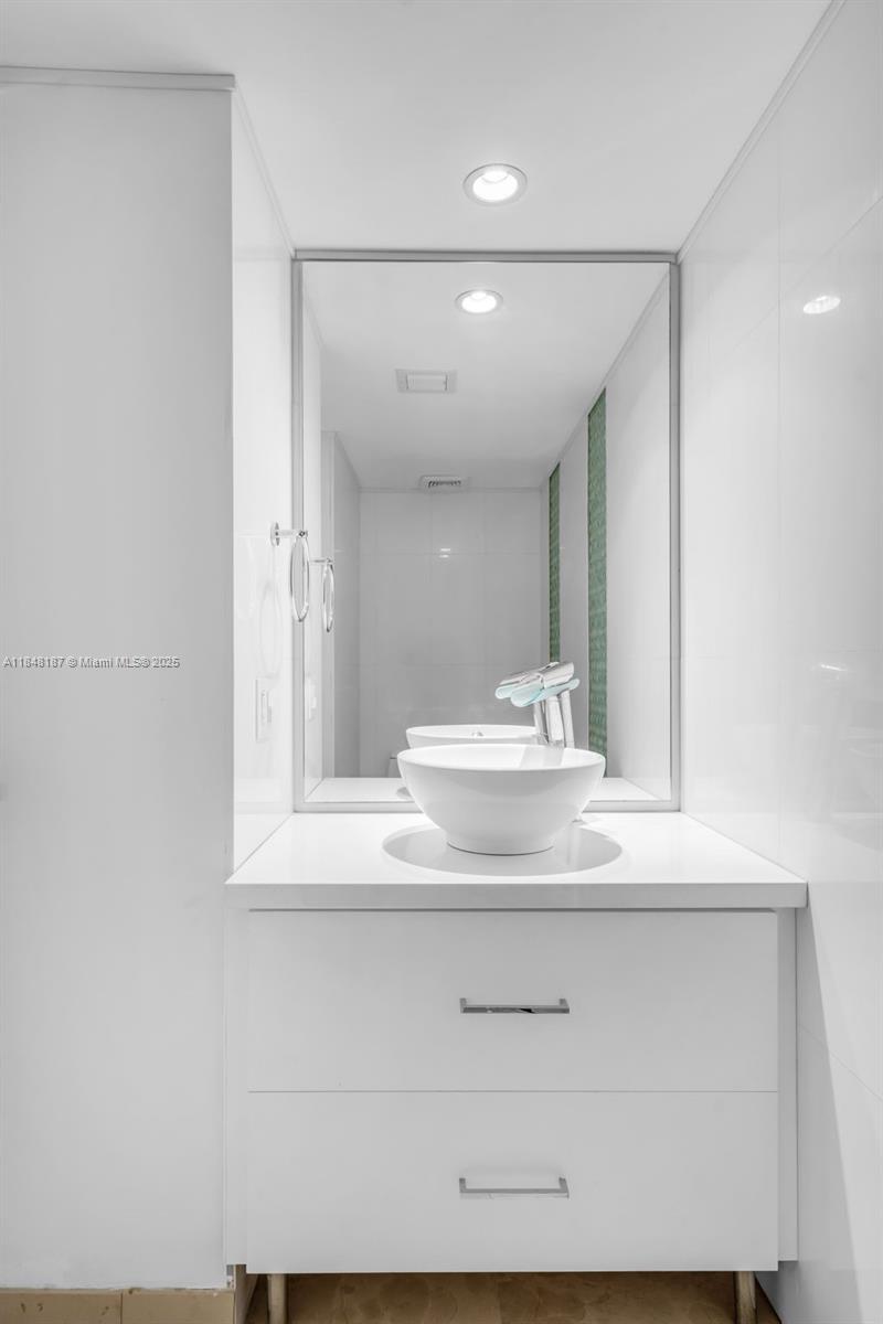 6301 Collins Avenue, Unit 1903 Miami Beach, FL 33141 - Photo 26 of 45 a bathroom with a sink a mirror and a vanity