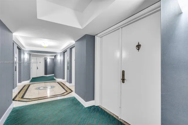 a view of a kitchen with refrigerator and white cabinets
