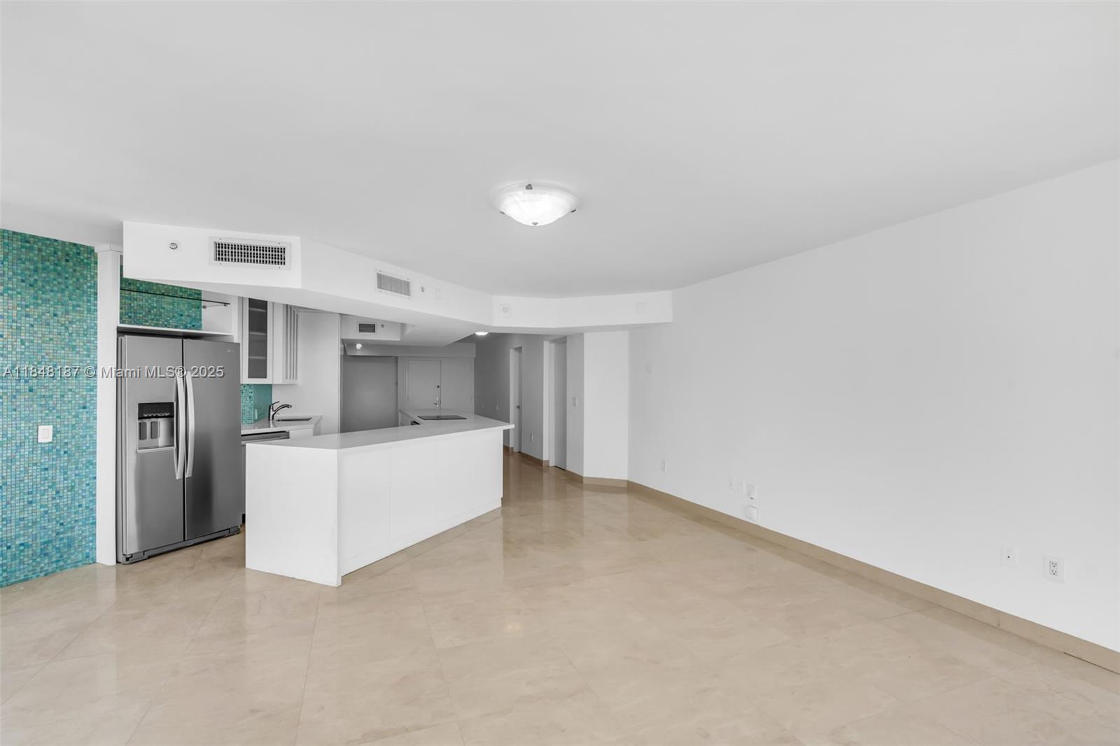 6301 Collins Avenue, Unit 1903 Miami Beach, FL 33141 - Photo 5 of 45 a view of a kitchen with refrigerator and white cabinets