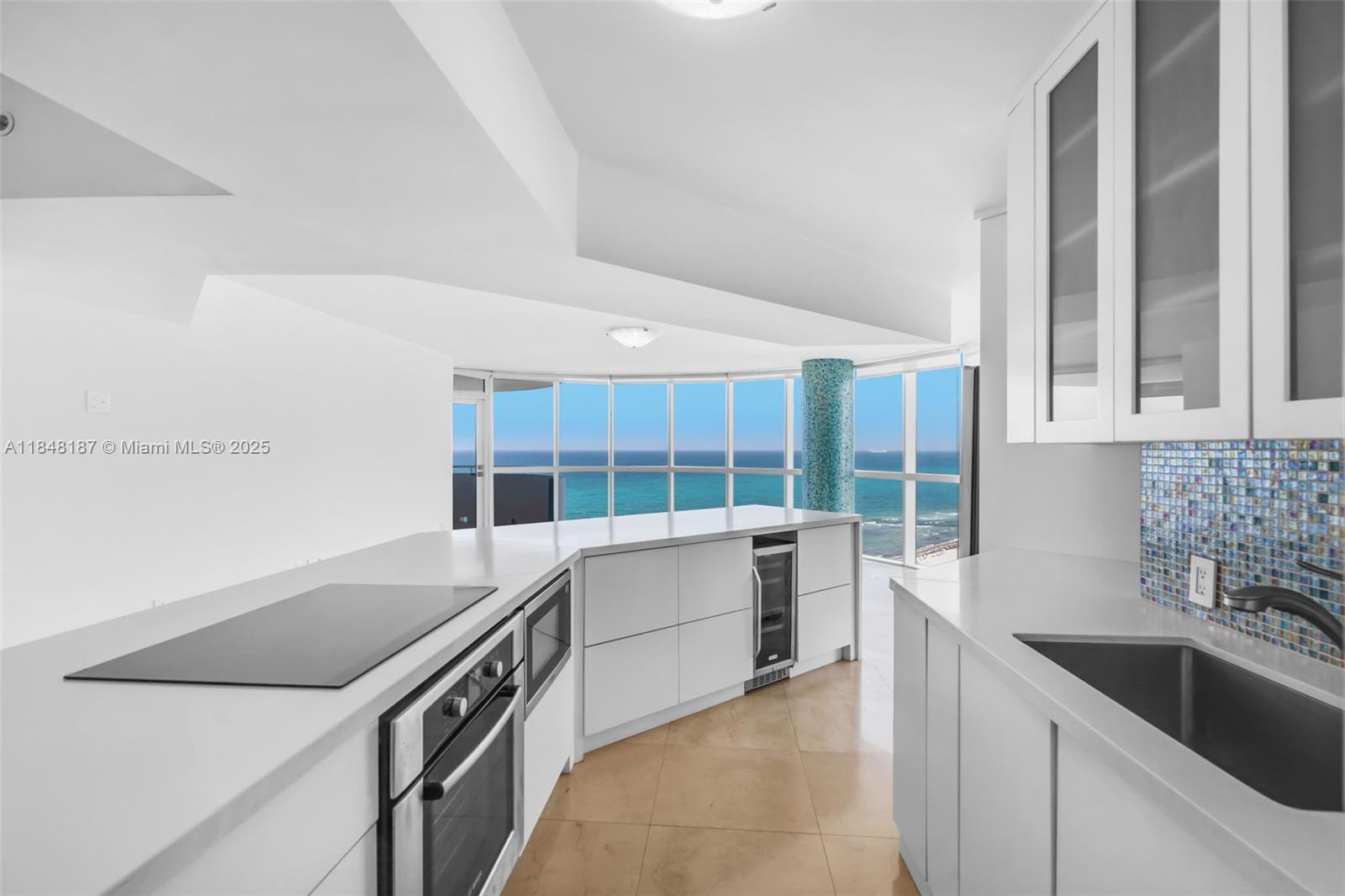 6301 Collins Avenue, Unit 1903 Miami Beach, FL 33141 - Photo 10 of 45 a kitchen with a sink and a stove top oven