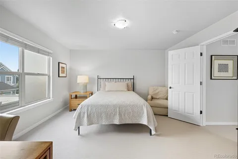 a bedroom with a bed and a large window