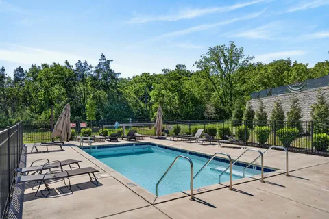 a view of a swimming pool with a patio and a yard