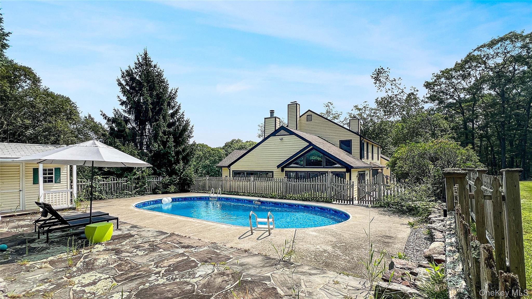 701 Highway 301 Cold Spring, NY 10516 - Photo 18 of 19 a view of swimming pool with lawn chairs under an umbrella