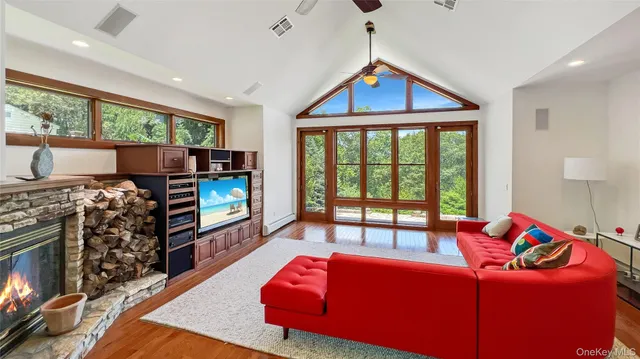 a living room with furniture a flat screen tv and a floor to ceiling window