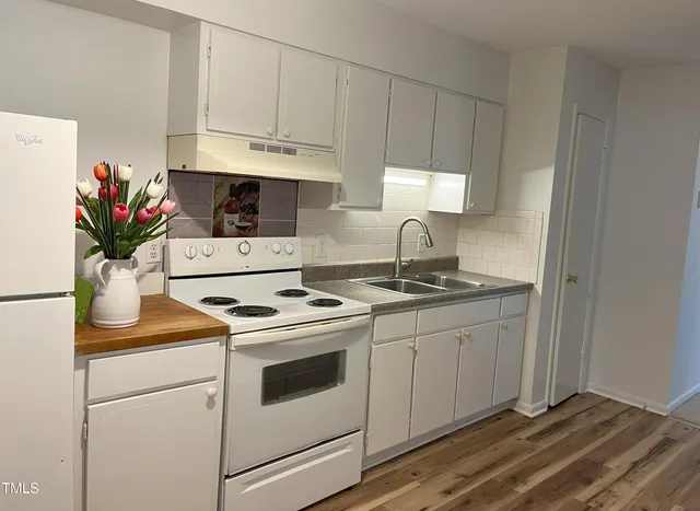 a kitchen with appliances a sink and cabinets