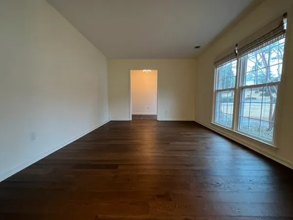 a view of a room with wooden floor chandelier and windows