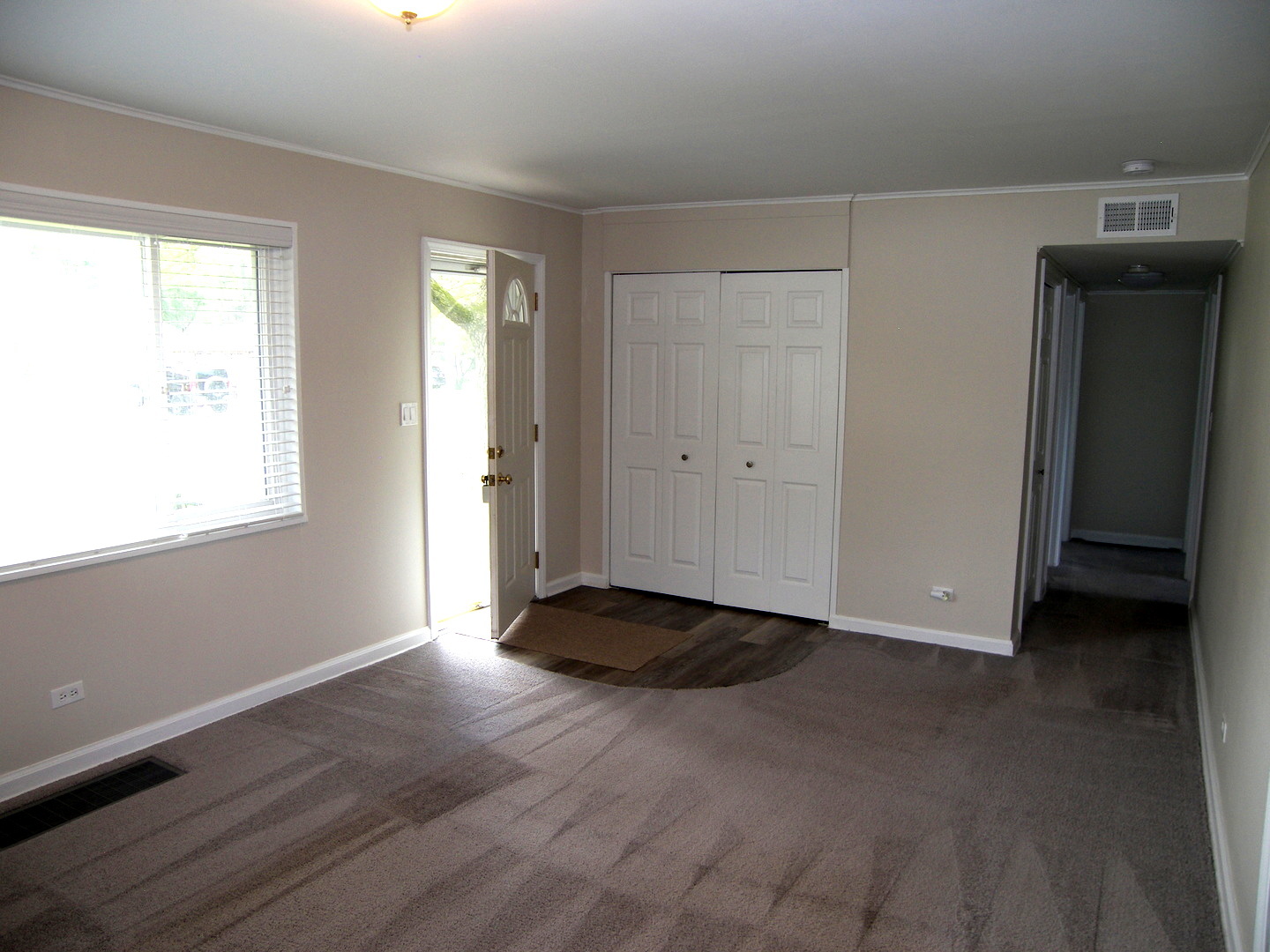 8 Crescent Road Lake Zurich, IL 60047 - Photo 3 of 17 a view of an empty room with wooden floor and a window