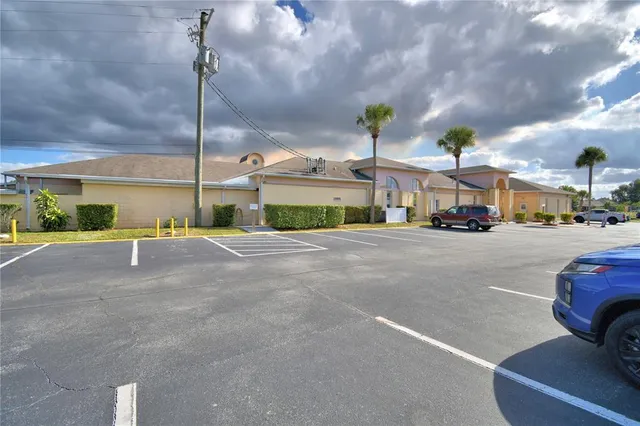 a front view of a building with cars parked
