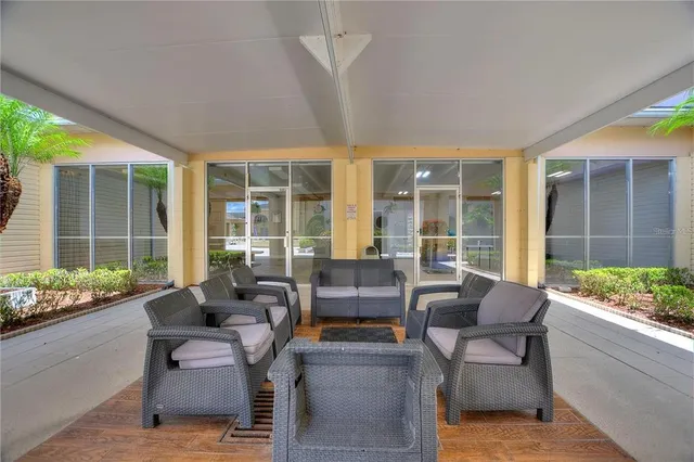 a living room with furniture and large windows