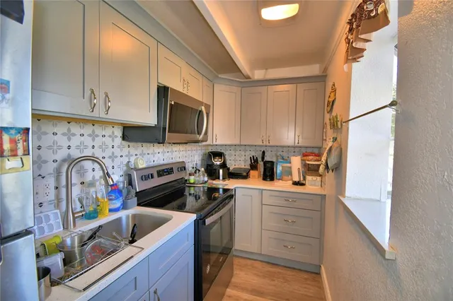 a kitchen with stainless steel appliances granite countertop a sink a stove and cabinets