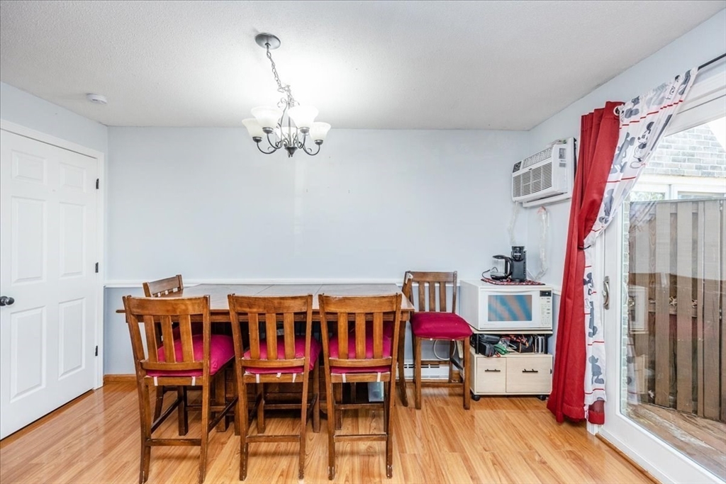75 Sandy Pond Road, Unit 7 Ayer, MA 01432 - Photo 12 of 37 a view of a dining room with furniture wooden floor and chandelier
