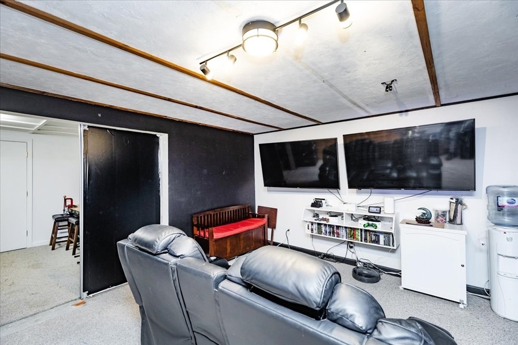 75 Sandy Pond Road, Unit 7 Ayer, MA 01432 - Photo 27 of 37 a living room with furniture and a flat screen tv