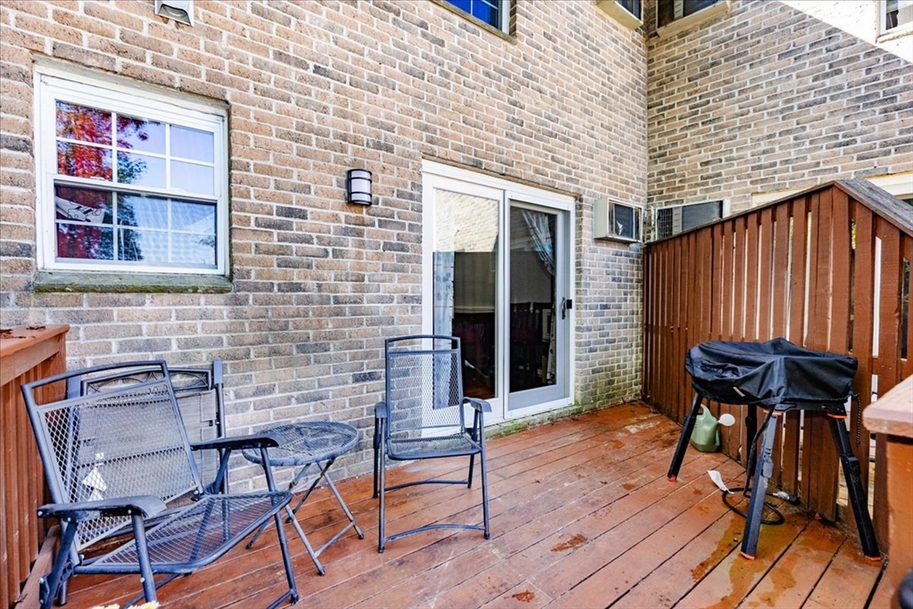 75 Sandy Pond Road, Unit 7 Ayer, MA 01432 - Photo 35 of 37 a view of deck with table and chairs and wooden floor