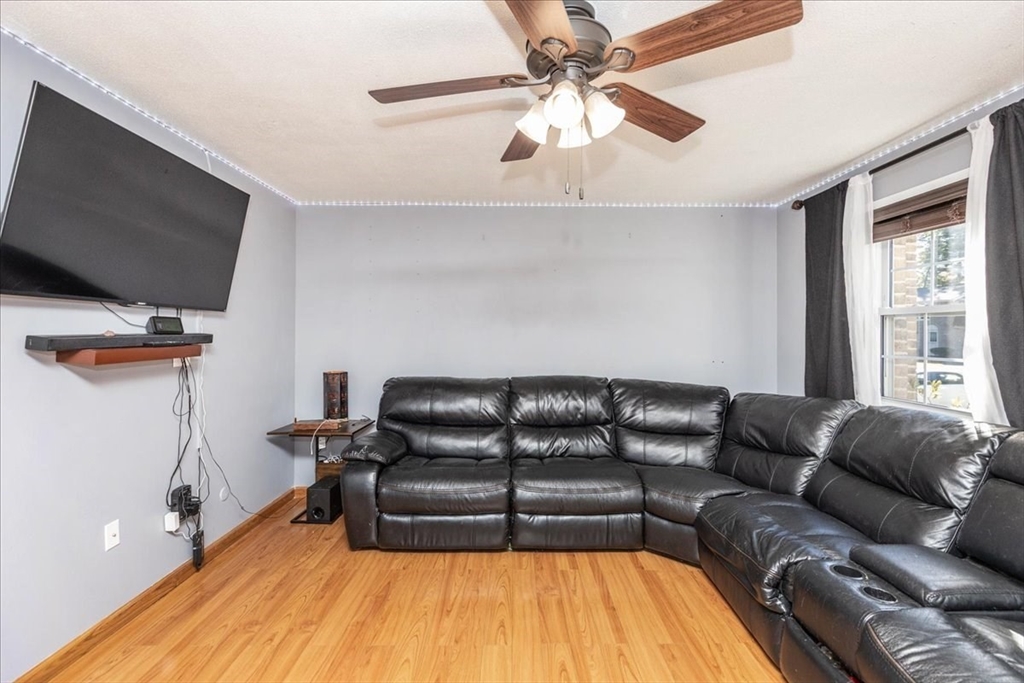 75 Sandy Pond Road, Unit 7 Ayer, MA 01432 - Photo 8 of 37 a living room with a couch and a flat screen tv