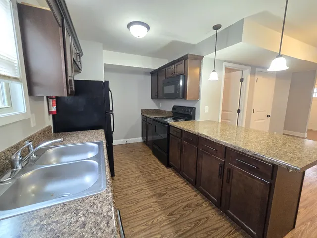 a large kitchen with stainless steel appliances kitchen island granite countertop a sink and a granite counter tops