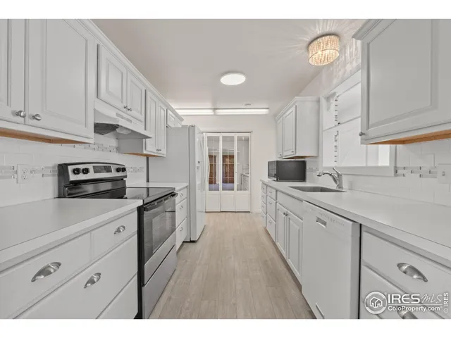 a kitchen with granite countertop white cabinets and stainless steel appliances