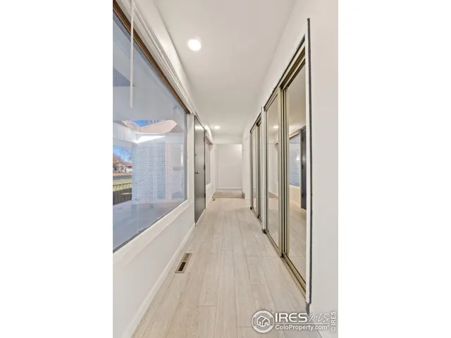 a view of a hallway with two couches and a view of bathroom
