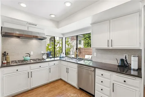 a kitchen with cabinets and wooden floor