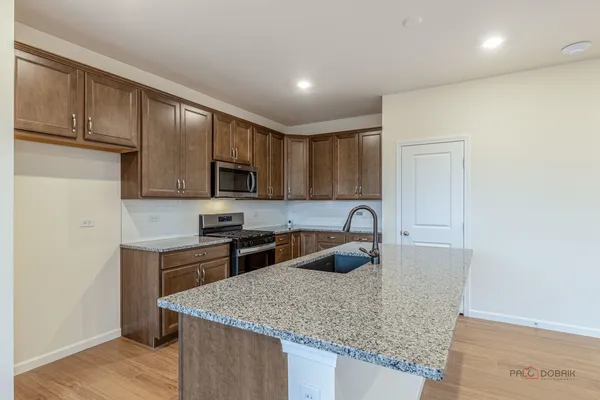 a kitchen with stainless steel appliances granite countertop a sink stove and refrigerator