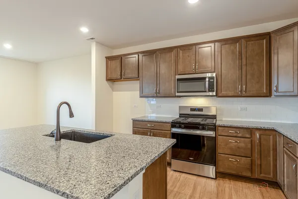 a kitchen with a sink a stove and cabinets