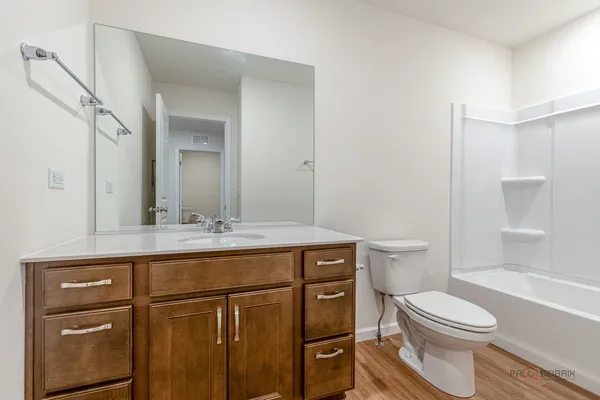 a bathroom with a granite countertop toilet sink and mirror