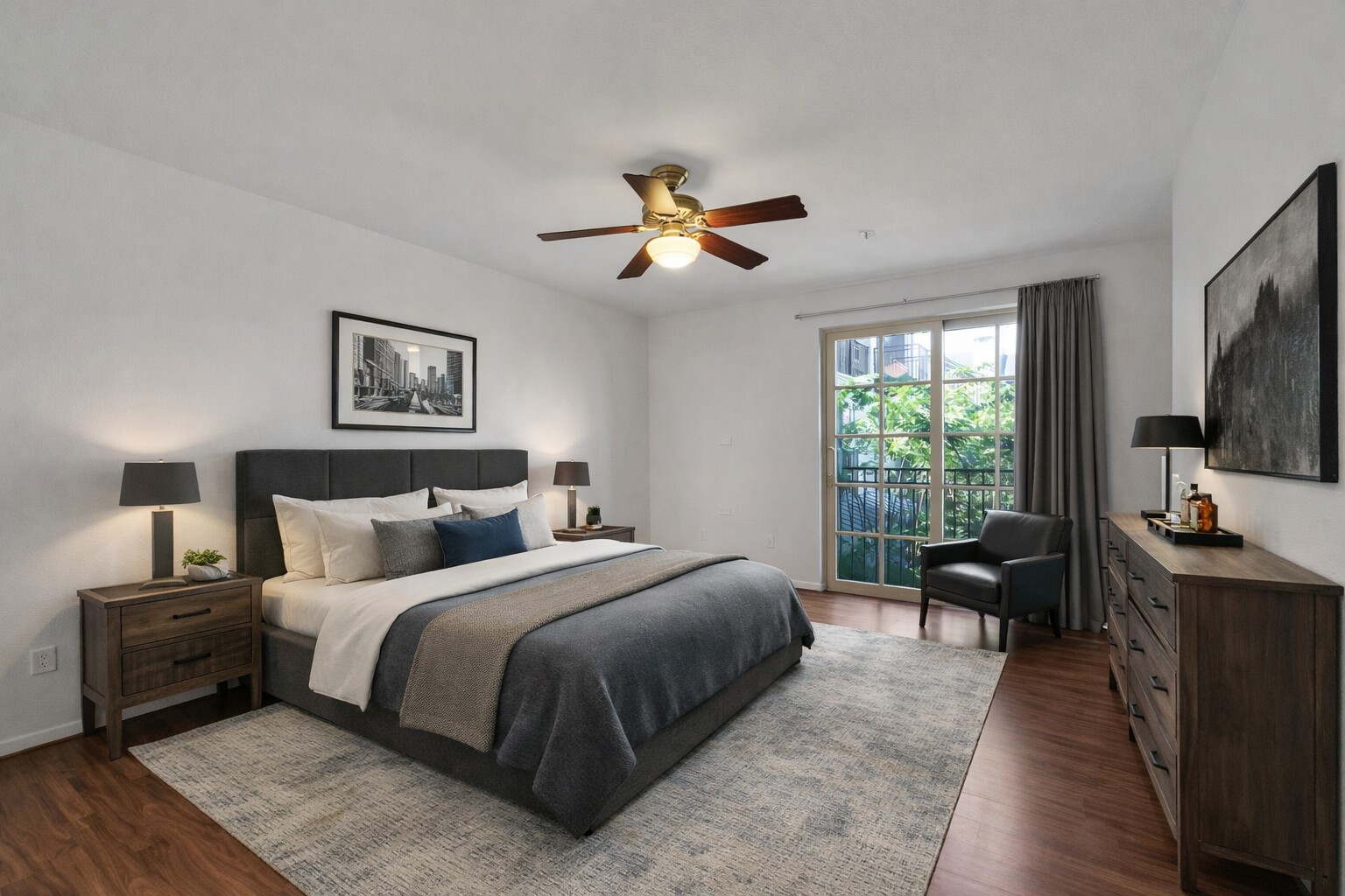 2216 Chenevert Street, Unit 6 Houston, TX 77003 - Photo 10 of 29 Upstairs Primary Bedroom: High-demand primary suite designed for rental longevity, featuring wood flooring, a Juliet balcony with Downtown and courtyard views, a built-in work area with storage, two separate closets, and a private ensuite bath...ideal for attracting and retaining quality tenants. Image is virtually staged.