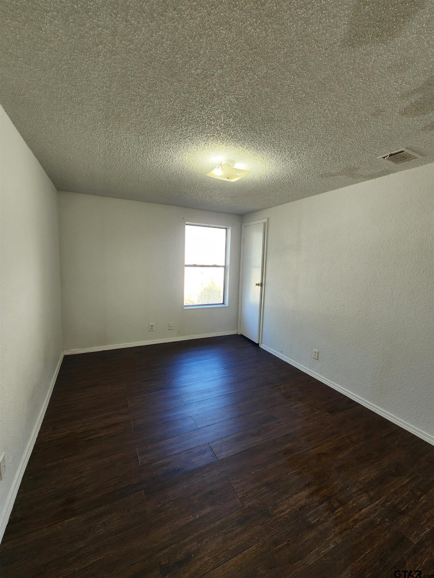 7679 Lindy Lane Frankston, TX 75763 - Photo 12 of 21 an empty room with wooden floor and windows