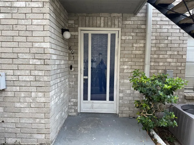 a brick building with a window and potted plants