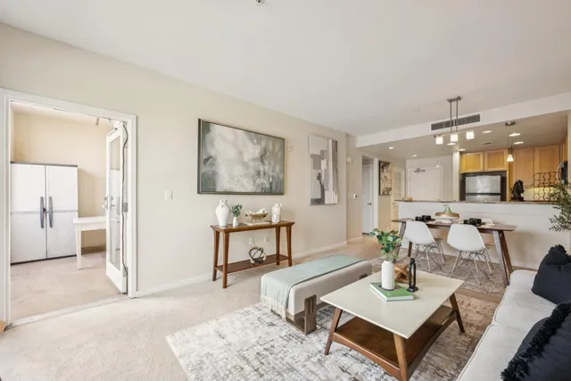 a living room with furniture and a dining table with wooden floor