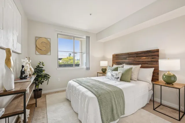 a bedroom with a bed and a lamp on dresser