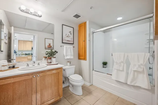 a bathroom with a double vanity sink toilet mirror and shower