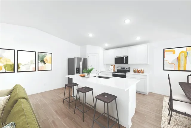 a living room with furniture a flat screen tv and kitchen view