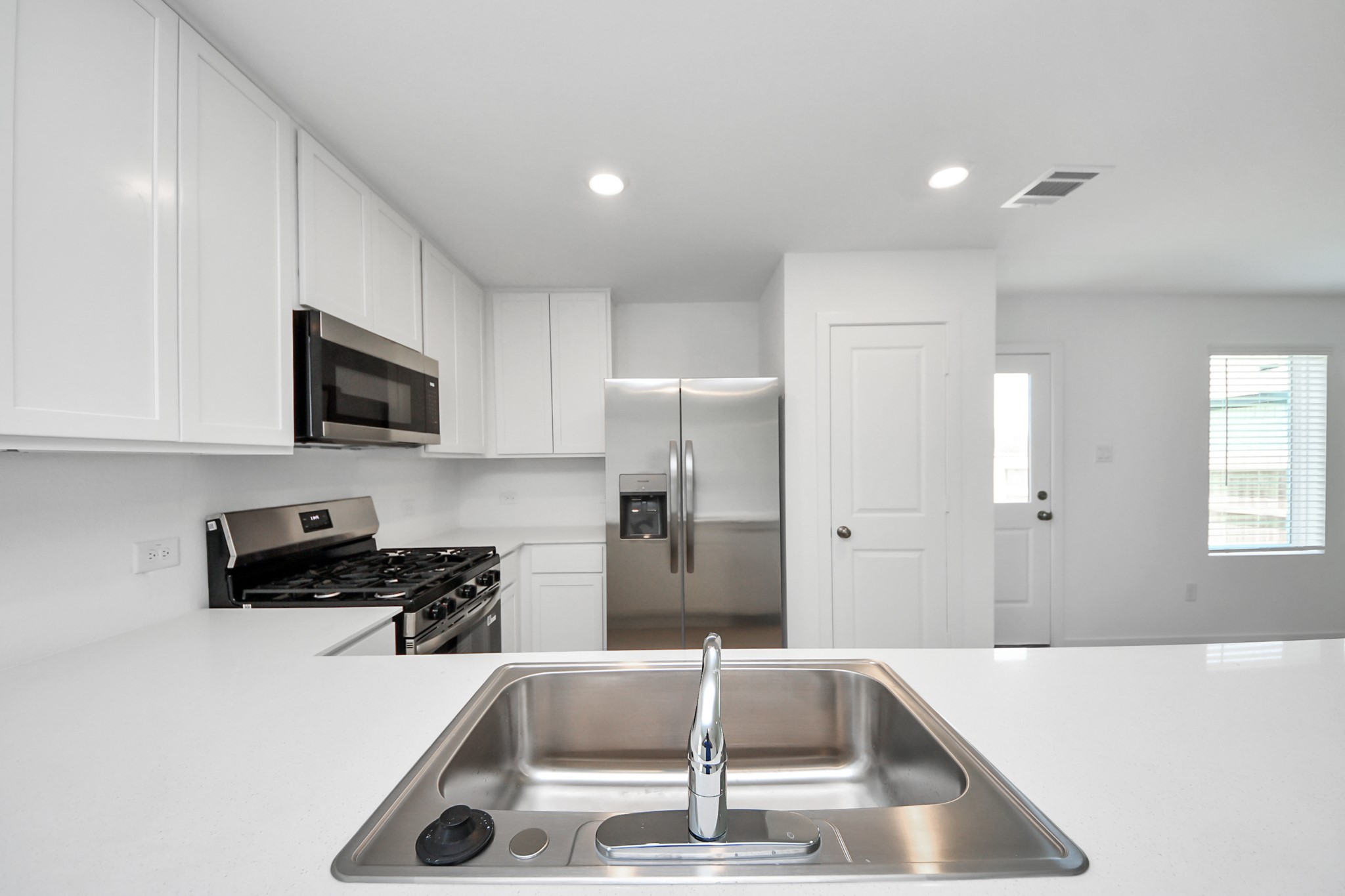 2931 Summer Breeze Way Angleton, TX 77515 - Photo 5 of 30 a kitchen with a sink a microwave and cabinets
